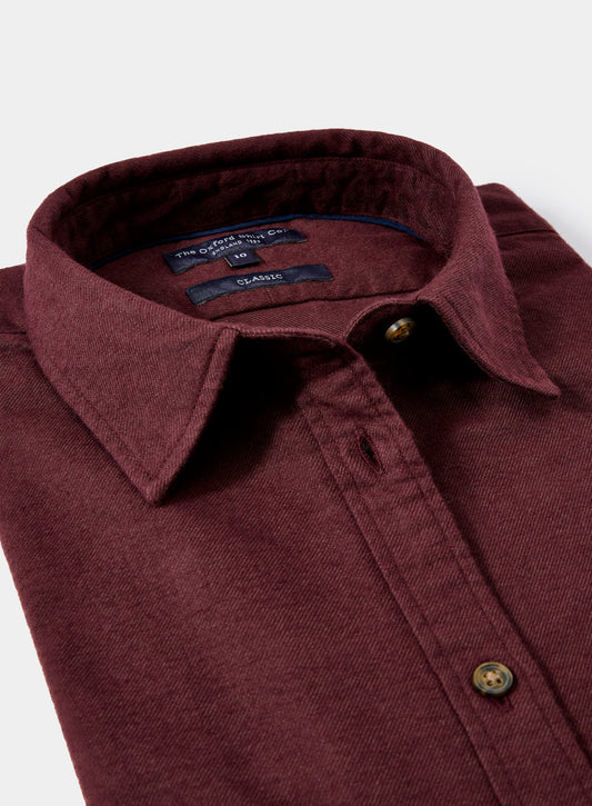 Close-up of a maroon shirt collar with buttons on a white background