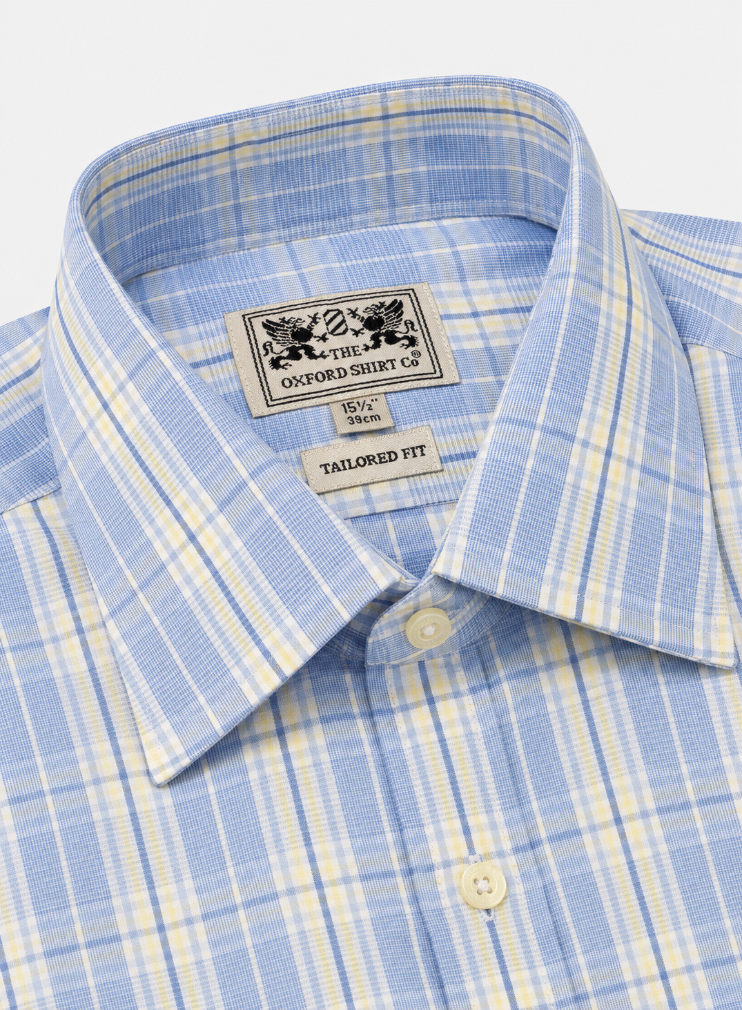 Close-up of a light blue and white plaid dress shirt collar with a visible neck label reading The Oxford Shirt Co.