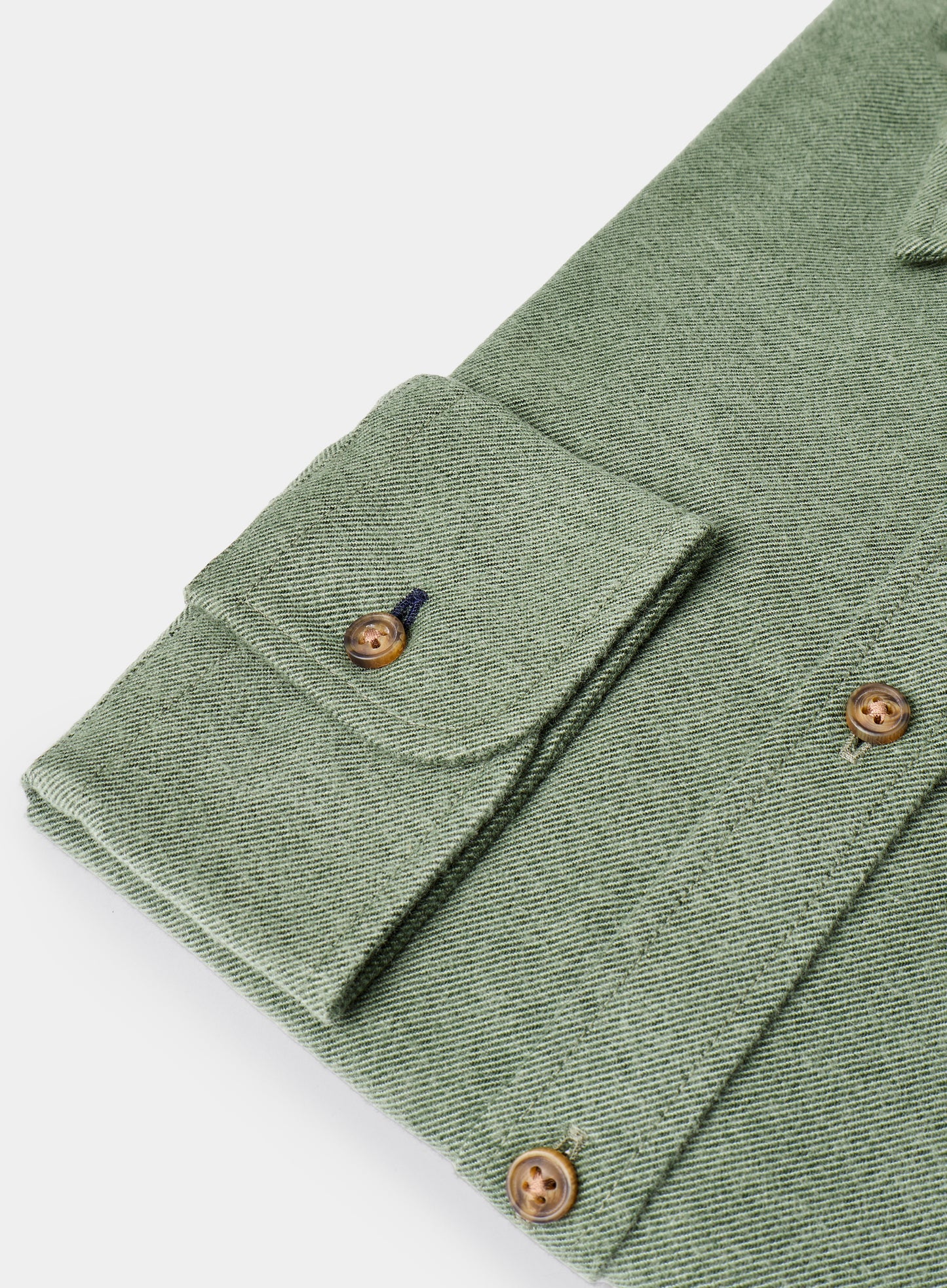 Close-up of a green fabric with buttons on a white background