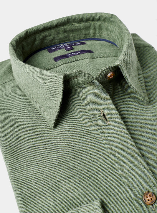 Close-up of a green shirt collar with buttons on a light gray background