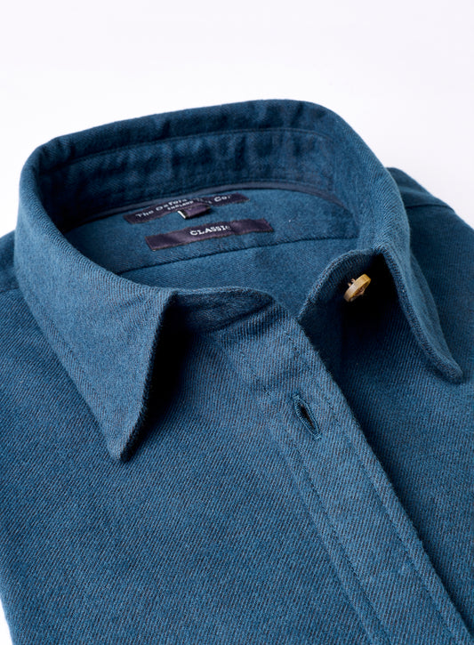 Close-up of a blue shirt with a collar and button on a white background