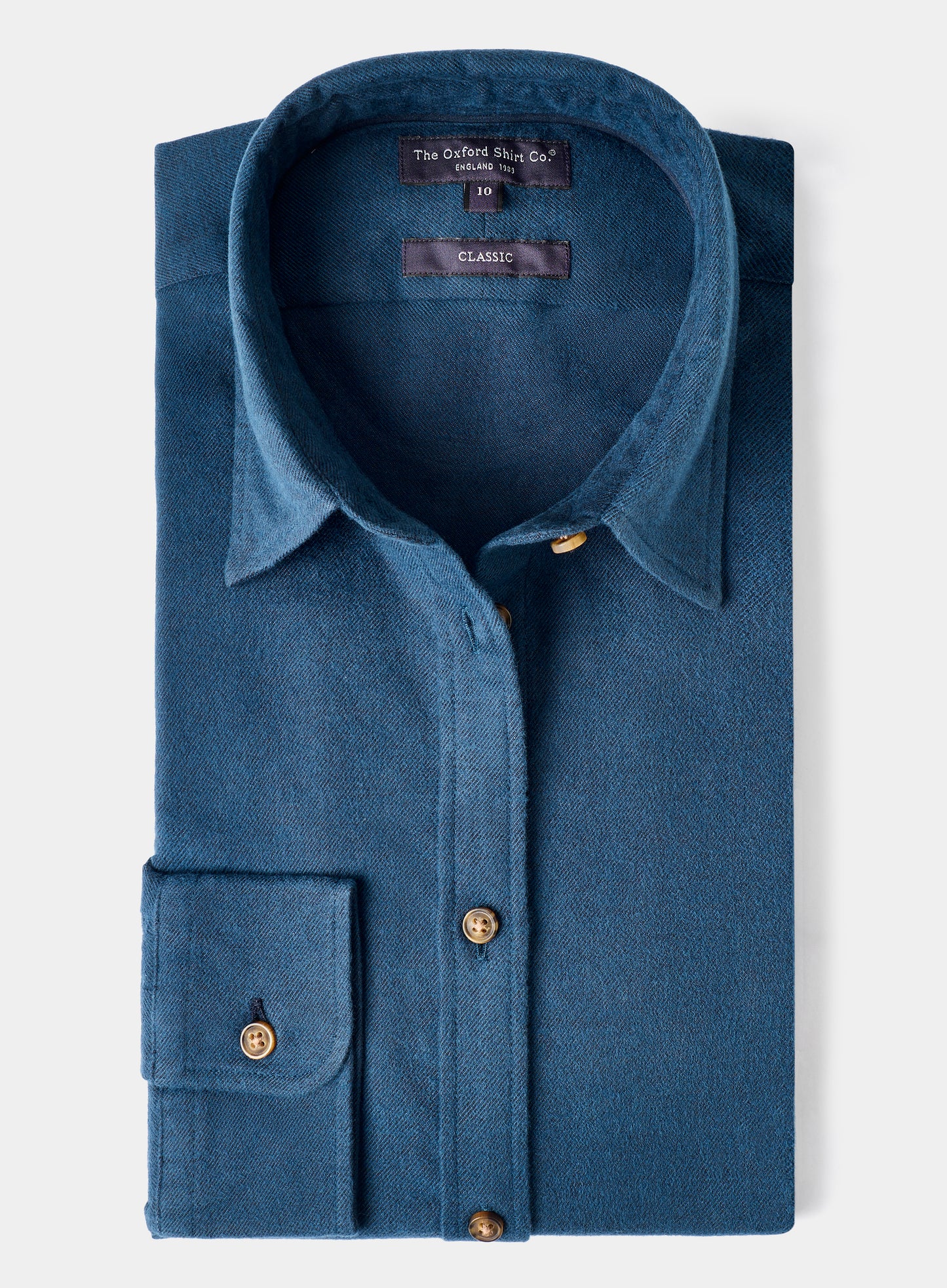 Folded blue shirt with gold buttons on a white background