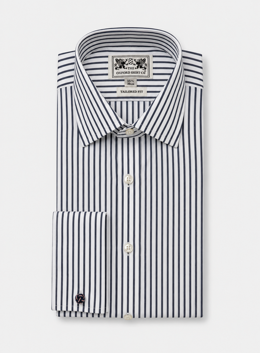 A folded dress shirt with vertical navy and white stripes, featuring a pointed collar, button front, and a single-button cuff. The neck label reads 'The Oxford Shirt Co.'