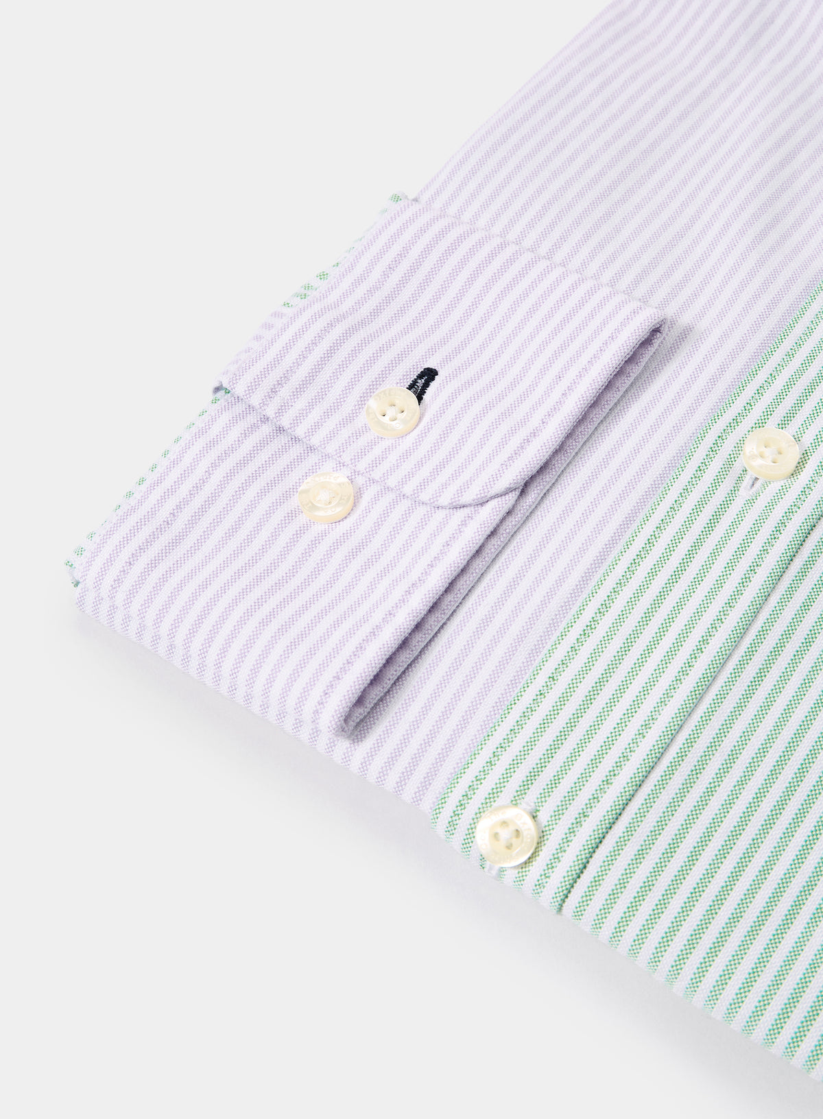Close-up of men's lilac and green patch stripe Oxford shirt cuff with contrasting striped panels and button detail
