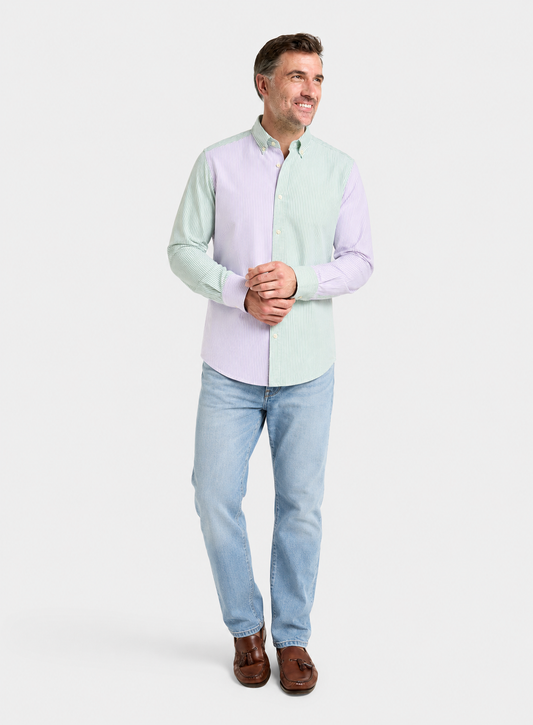 Man wearing a lilac and green patch stripe Oxford button-down shirt with blue jeans, full-length front view