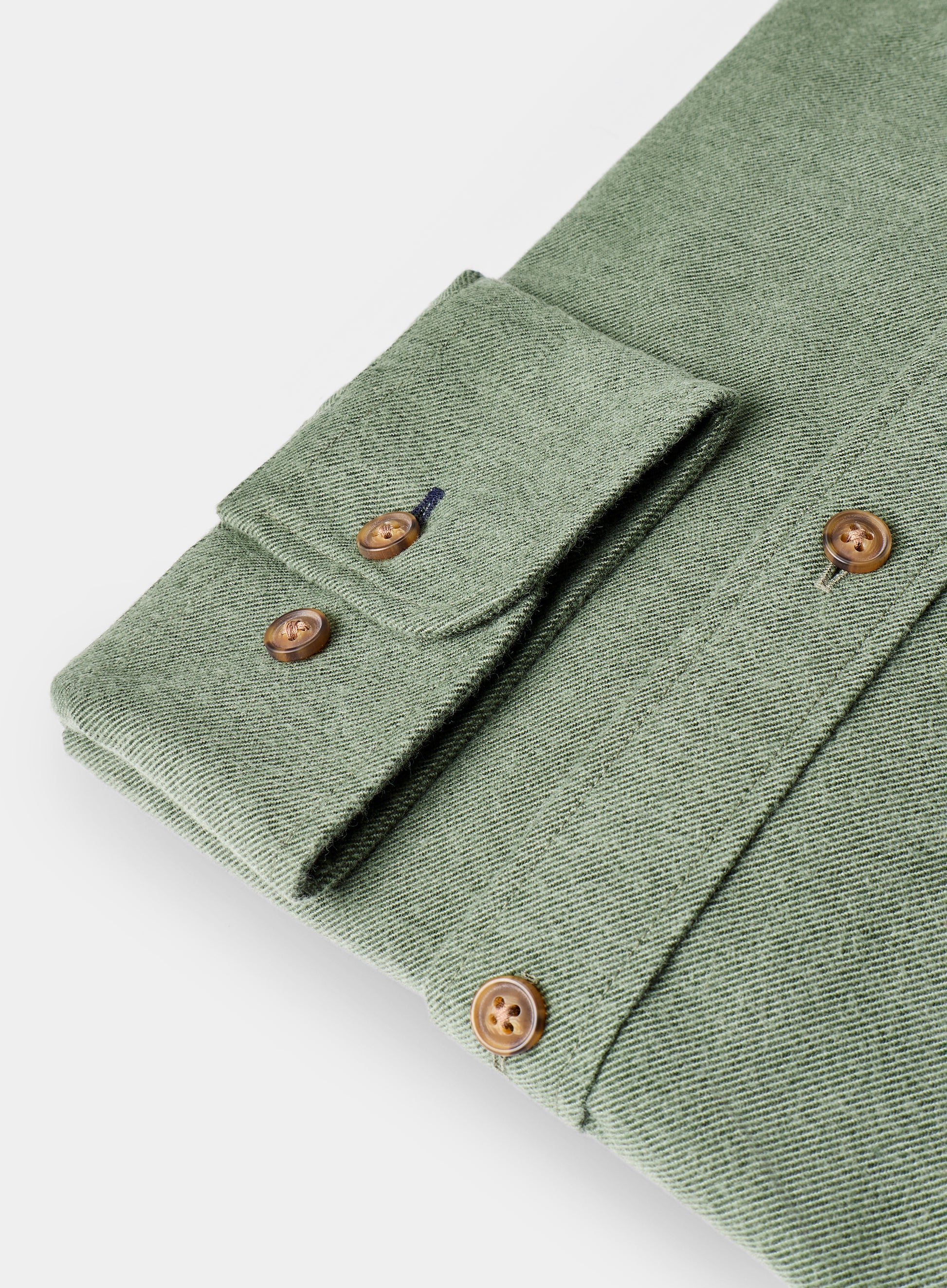 Folded green shirt with brown buttons on a white background
